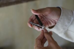 close up of a man cutting his fingernail using nail clipper